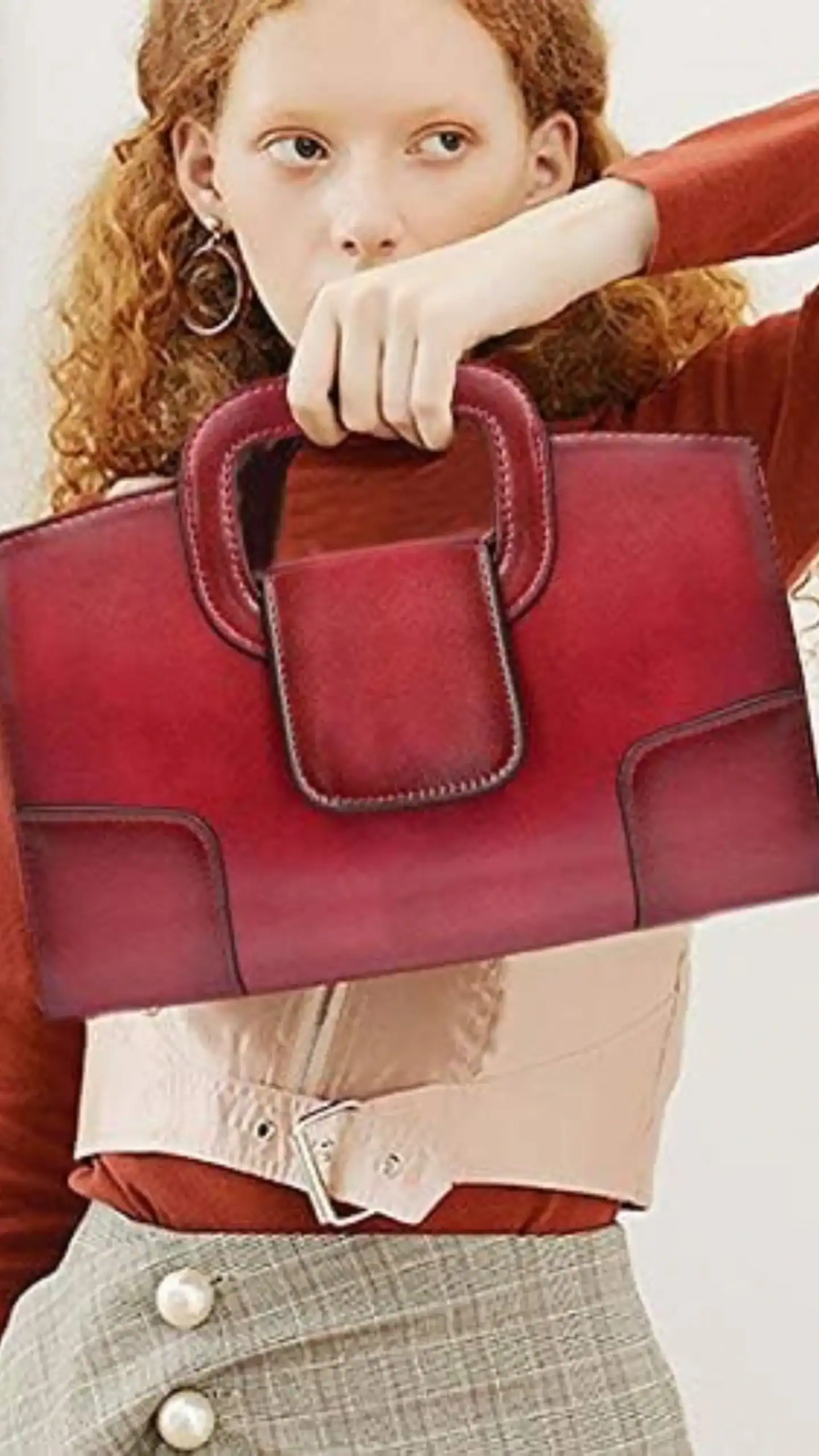This structured tote bag features a sleek silhouette with a top handle, crafted from glossy PVC that mimics leather for a polished appearance. In a deep burgundy hue, it showcases minimalist design elements, including smooth lines and a front flap pocket, making it an ideal accessory for both professional settings and stylish casual outings.