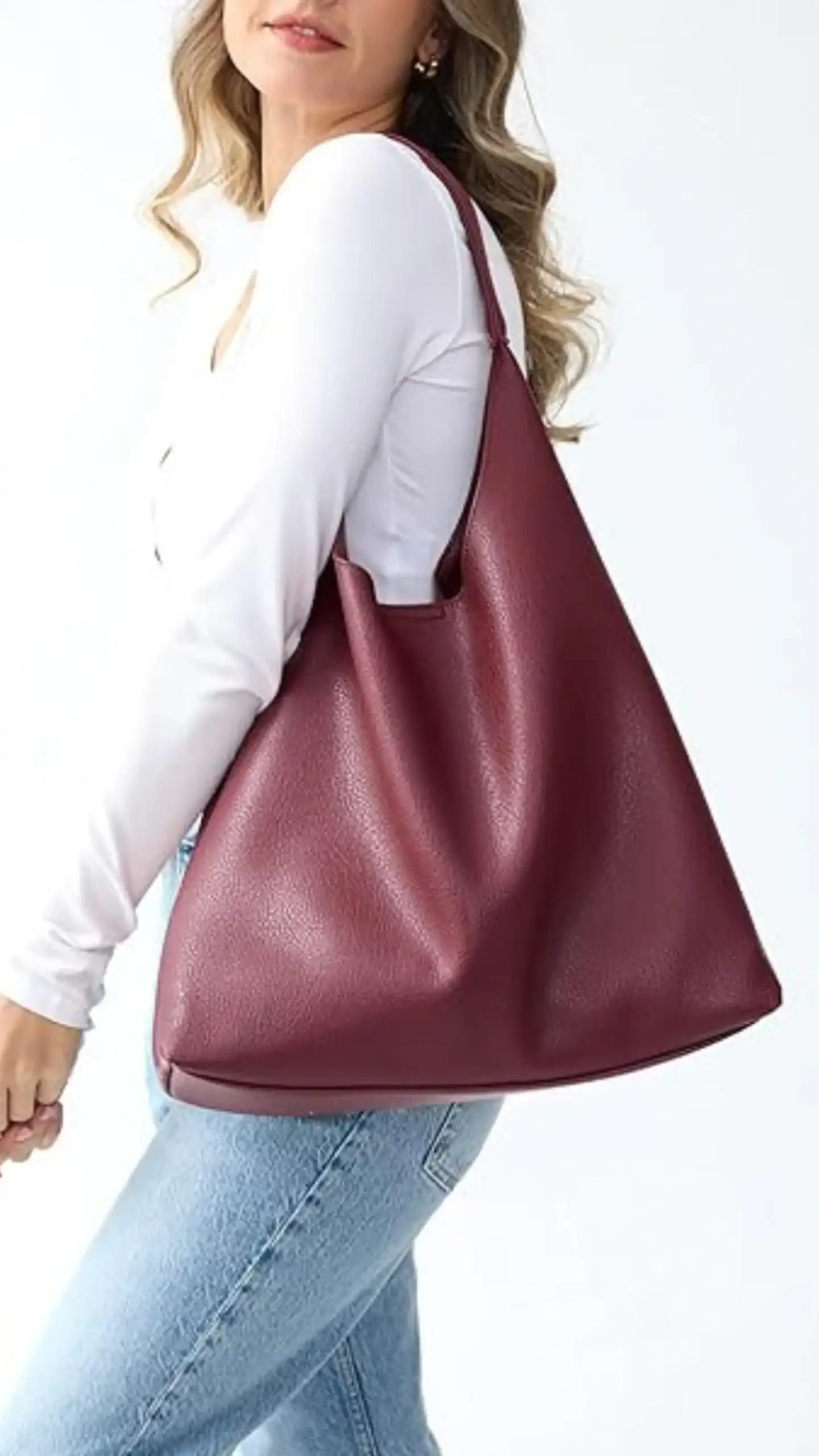 This large handbag features a relaxed, slouchy silhouette, made from textured burgundy PU leather that combines a matte finish with a subtly pebbled appearance. With its minimalist design and spacious zip compartments, this versatile tote is ideal for everyday use, making it perfect for both professional settings and casual outings.