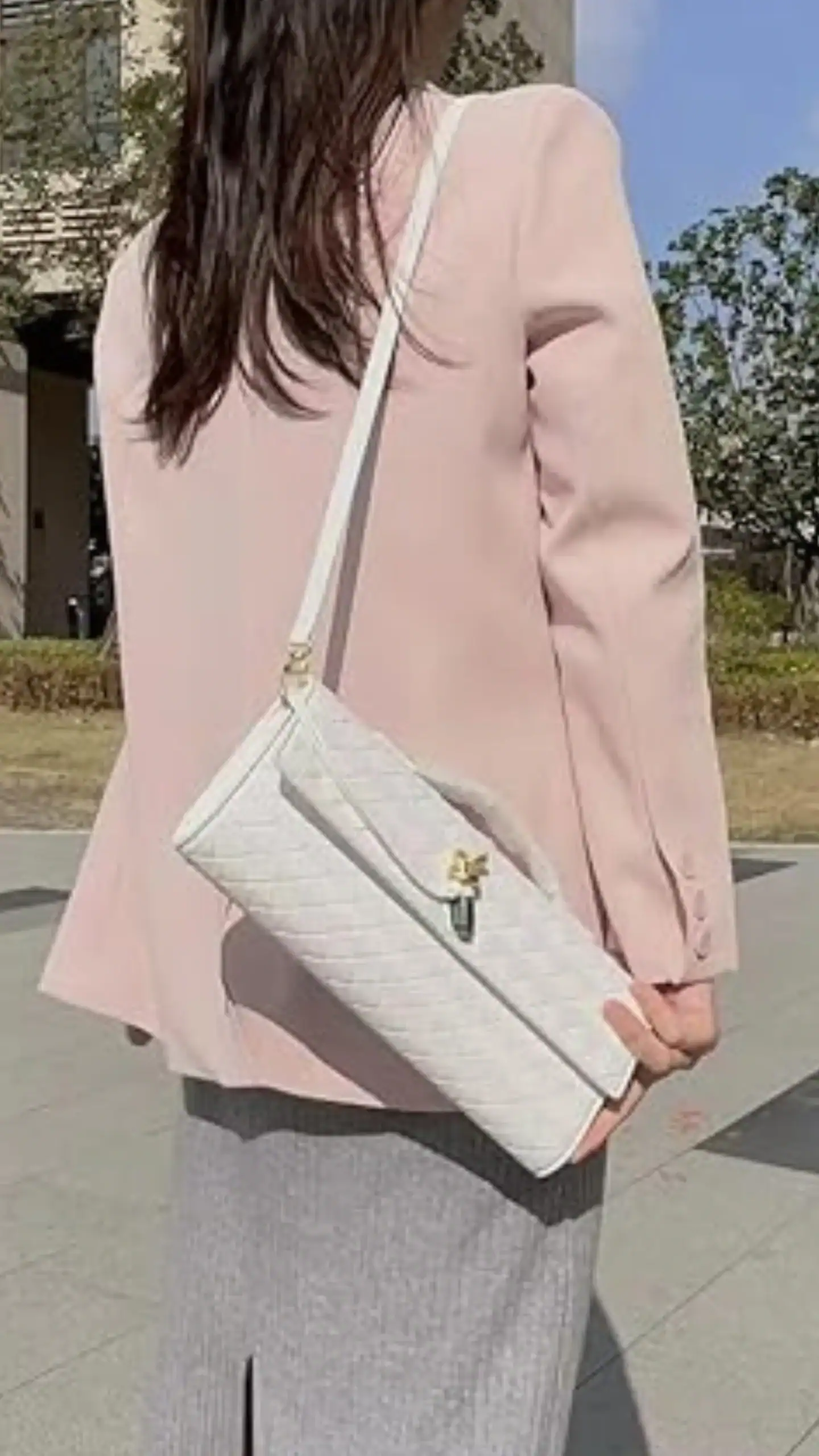 This handbag features a sleek, rectangular silhouette with a top handle and a crossbody strap for versatile carrying options. Made from textured white synthetic material with a quilted pattern, it exudes a fresh, modern vibe, ideal for casual outings or summer events.