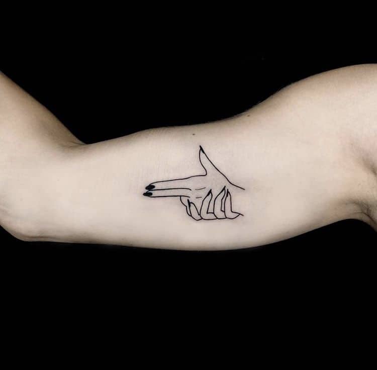 Gun finger minimalist tattoo