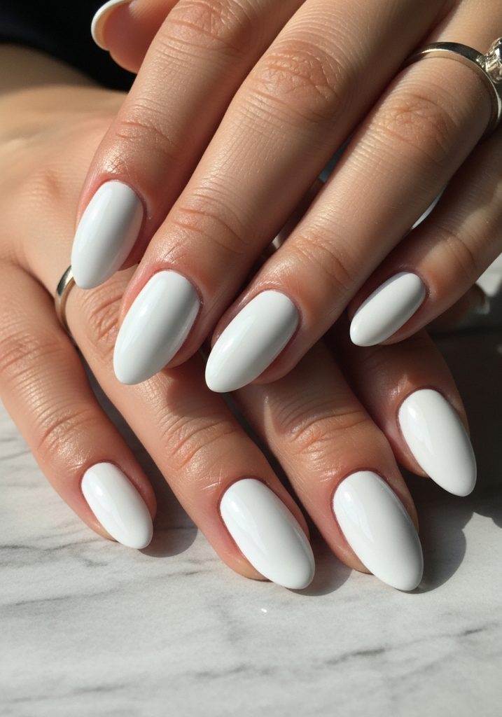 Short almond-shaped white chrome mirror finish prom nails on light grey marble