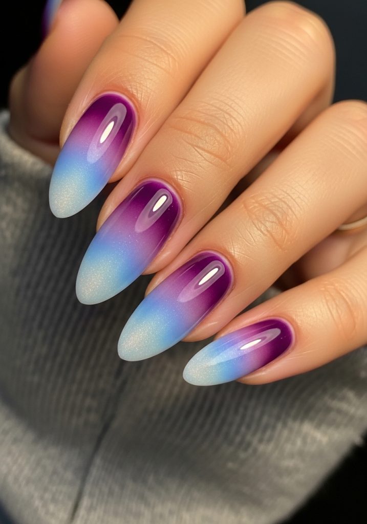 Medium almond-shaped nails with a dreamy aura effect fading from purple to blue