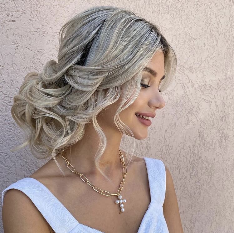 Mid-part curls in a low bun