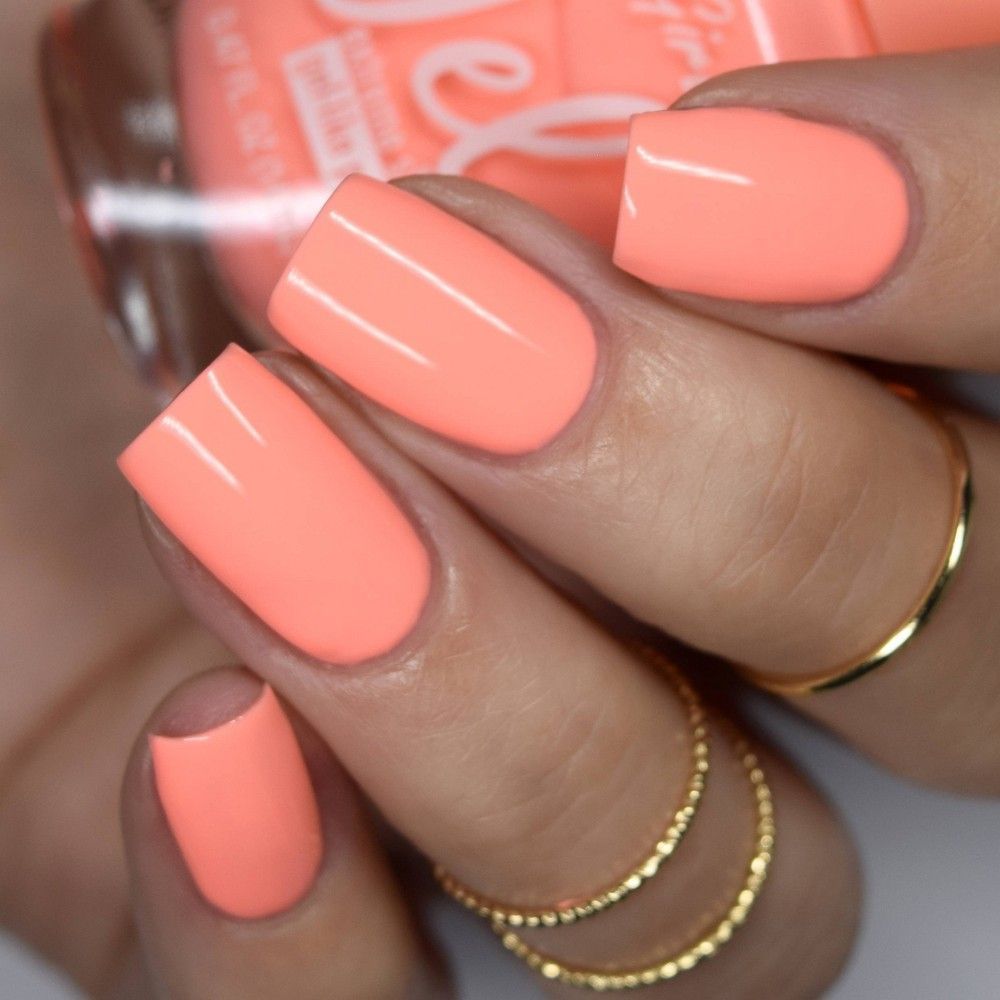 Close-up of a hand with all fingernails painted a solid, bright coral color.
