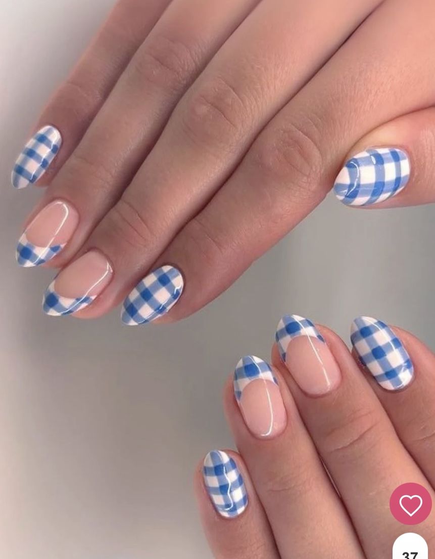 Close-up of hands with blue and white gingham nail art. Some nails are fully patterned, while others have a French tip style