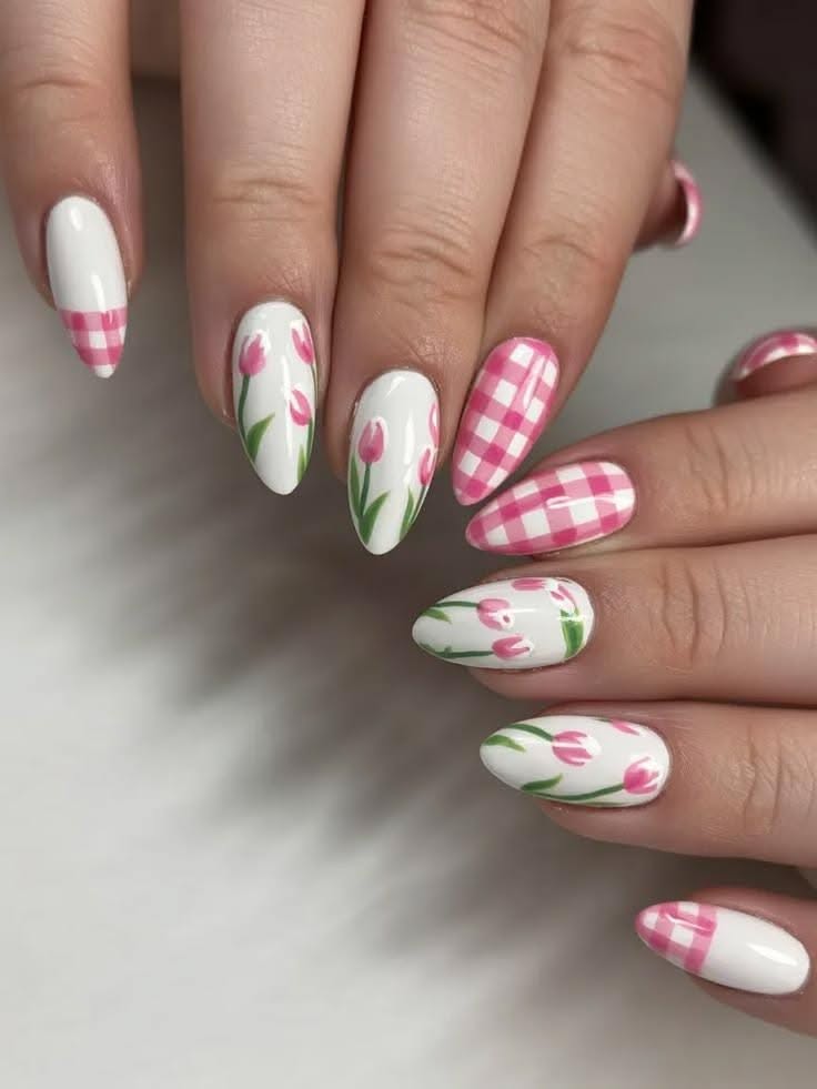 Almond-shaped nails feature a soft pink and white gingham pattern interspersed with delicate hand-painted pink tulips with gr