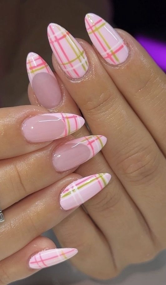 Almond-shaped pink nails with a plaid French tip design in pink, green, and white on some nails, and full plaid on others.