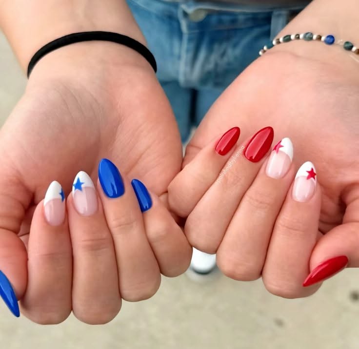 Hands with red, white, and blue nails, some solid colors, some with white tips and stars.